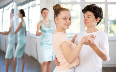 Girl and a boy are having fun learning to dance tango at a choreographic school