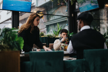Focused young professionals working together in a stylish city cafe. An ambient meeting spot for business talks among contemporary entrepreneurs.