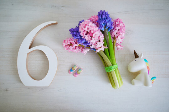 Bunch of light pink and purple hyacinths and white wooden number six. Sixth birthday or anniversary concept