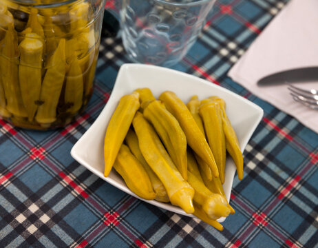 Homemade organic marinated pickled okra on a ceramic plate, portuguese snack