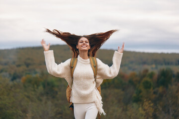 Mountain Adventure: Smiling Woman on Cliff, Enjoying Outdoor Travel and Hiking in Springtime