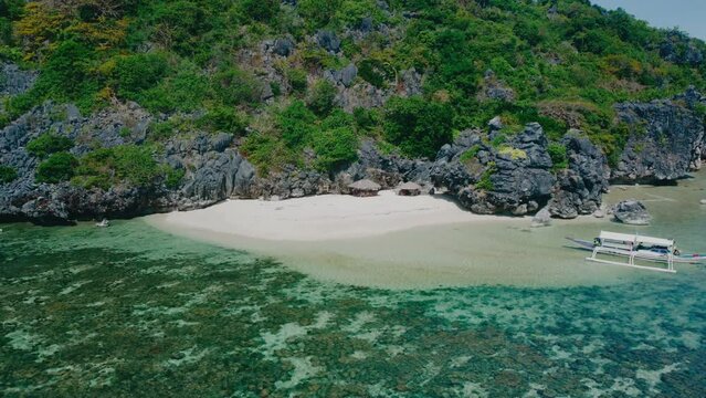 Aerial view 4k drone shot of small islands and beaches around Calauit National park Coron island, the Philippines. Crystal clear turquoise blue waters, palm tree lined white sandy beaches, and visible