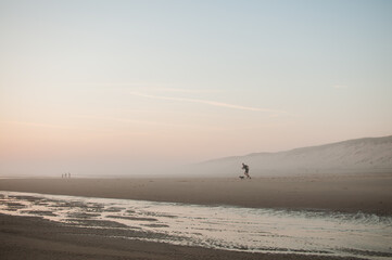 person walking on the beach at sunset