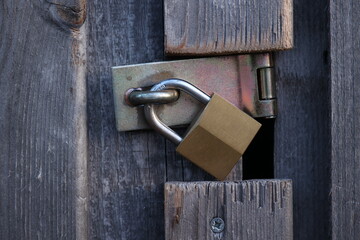 A gold lock is on a wooden door - 751004211