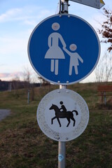A sign with a woman and child on it and a horse on the other side - 751004478
