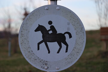 A sign with a horse and a person riding it - 751004628