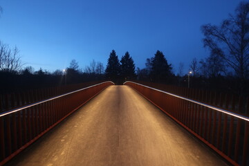 A bridge lit up at night with a dark sky in the background - 751005098