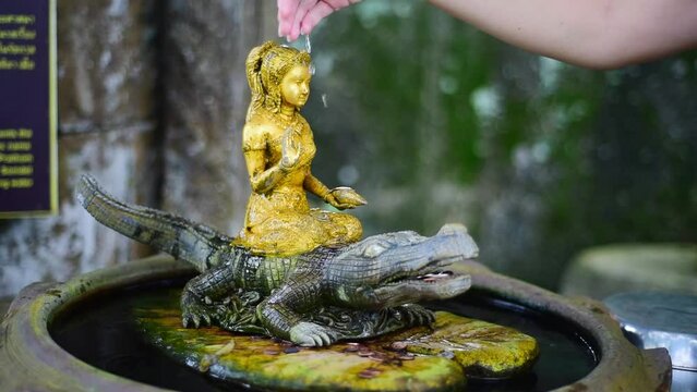 ritual in a buddhist temple. Gold statue of the goddess Dharani Mata, where you can throw a coin and make a wish, near Big Buddha Phuket