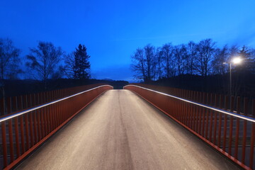 A bridge with a red railing and lights on it - 751005294