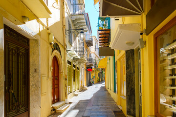 A colorful and narrow alley of shops and cafes in the historic old town center of Naplio, Greece, a coastal city in the Peloponnese region of Southern Greece.