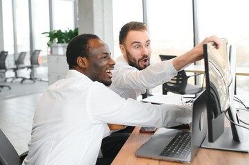 Two confident businessmen, financial analysts or investment advisers sitting at office desk