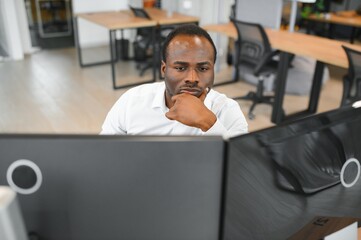 African-American broker works in office using workstation and analysis technology