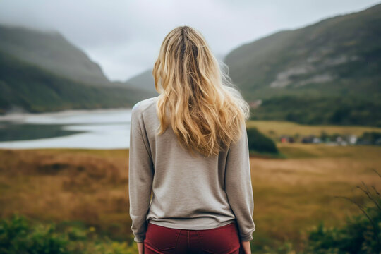 Young woman standing on a hill looking to the valley below mindfulness concept mind and body becoming one with the world in a good place wellbeing