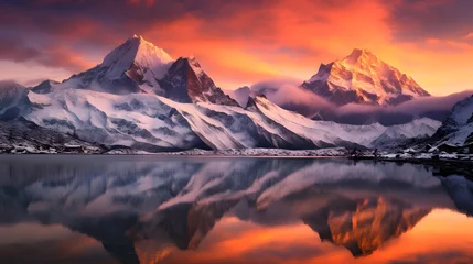 Wandaufkleber Panoramic view of snow-capped mountain peaks reflected in the lake at sunset © Iman