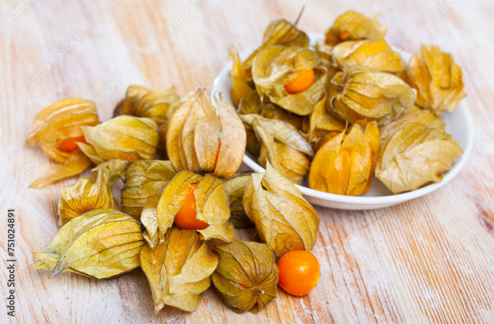 Wall mural ripe peruvian physalis fruits on wooden surface. concept of health benefits of fruits