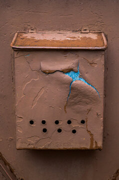 An old rusty mailbox on the wall.