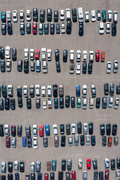 Aerial view of large parking lot full of various modern cars