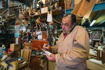 Senior carpenter talking on smartphone