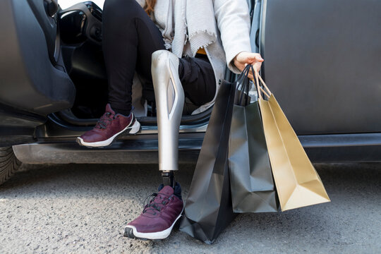 Anonymous Woman Stepping out of the Car holding Shopping Bags
