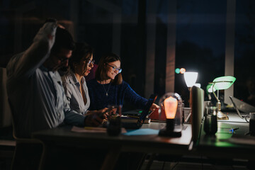 Multigenerational team working late, collaborative meeting in office setting.