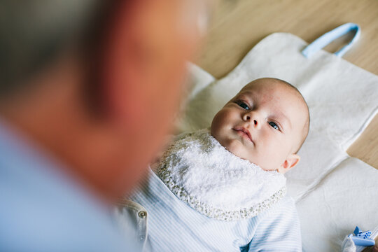 Grandfather changing diaper for newborn grandchild 