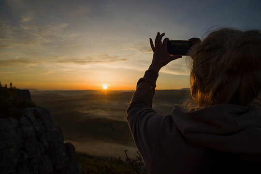 Woman making a picture of sunrise 