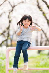 桜並木の公園で遊んでいる姉妹