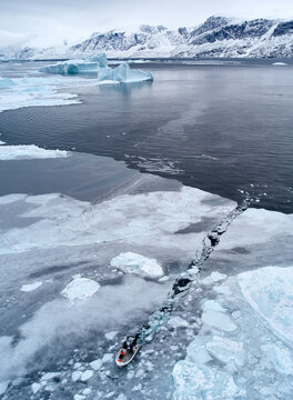 Indigenous Inuit boat fishing in Arctic sea ice