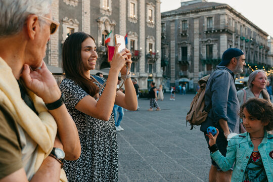 Group of tourists taking pictures and talking in old Italian town