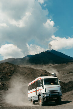 Van driving back on path from Mount Etna with active volcano 