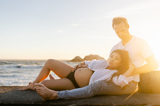 Husband and Pregnant Wife at Ocean for Golden Hour
