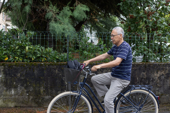 senior man riding bicycle in summer, active elderly man