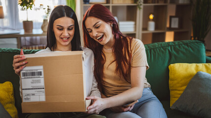 two women young teenage females at home open post package box