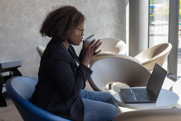 business woman plus size drinking coffee and reading email in cafe