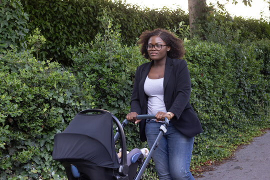 woman walking outside with baby in stroller pram