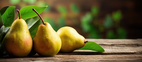 Three ripe pears are carefully placed on a wooden table, showcasing their vibrant colors and fresh appearance. The scene promotes a healthy lifestyle and veganism.