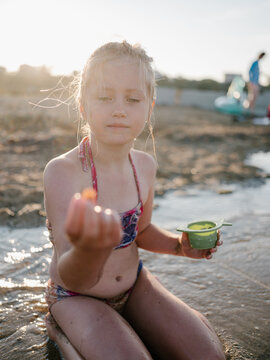 Girl showing seashell she found on the beach