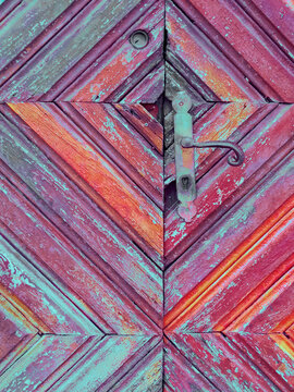 Old wooden door with patterned faded cubes texture.