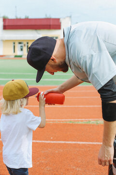 father giving water to his son