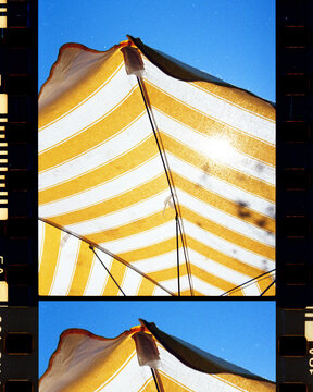 Yellow Striped Umbrella Against Blue Sky, Vintage Aesthetic