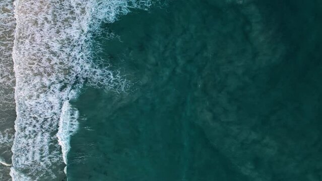 Waving ocean. Foamy turquoise water surface sparkling. Aerial top view shot