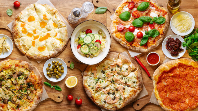 Table in cafe full of fresh pizzas 