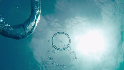 Divers create bubble rings while diving