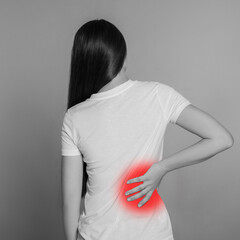 Woman suffering from rheumatism on light background. Black and white effect with red accent in...