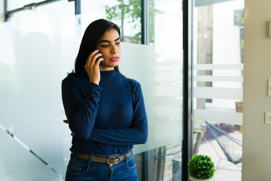 Serious Latin businesswoman taking and important call in a meeting room