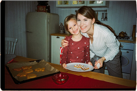 Female with kid with plate of Christmas cookies, ugc