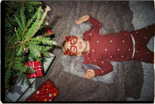 Playful child under Christmas tree, ugs
