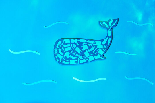 Different waste polluting sea and beach in a shape of whale.