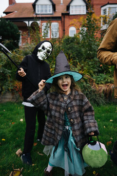 Kids dressed as a witch and skeleton for halloween