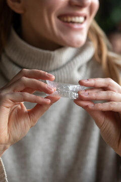 White Woman holding aligner 